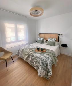 塔拉韦拉·德·拉·雷纳Apartamento La Muralla的白色卧室配有床和椅子