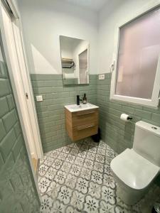 塔拉韦拉·德·拉·雷纳Apartamento La Muralla的一间带卫生间、水槽和镜子的浴室