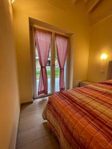 赫拉弗多纳Casa Tortora的一间卧室配有床和一个带粉红色窗帘的窗户。