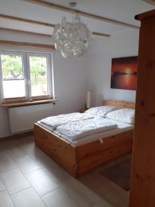 普劳西Ferienhaus Fiete的一间卧室配有一张木床和吊灯。