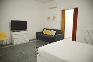 布林迪西La Casa di Eva的一间卧室配有一张床、一张沙发和一台电视