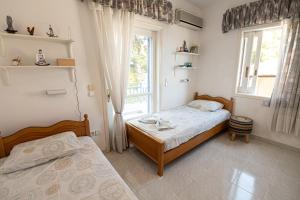 波罗斯Rigos House at Askeli beach, Poros island的一间卧室设有两张床和窗户。