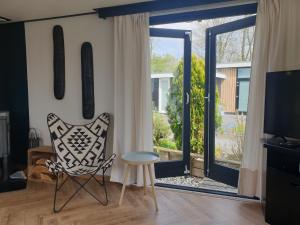 赫劳Vintage chalet Fereale II的客厅配有椅子和滑动玻璃门