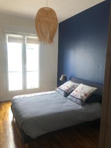 布雷斯特L'Aiguillon, bel appartement hyper-centre的一间卧室设有蓝色的墙壁和一张带枕头的床。
