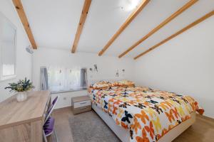 木洛希尼Apartments Čikat Mali Lošinj的一间卧室配有一张床和一张木桌