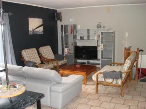 Courcellesappartement Courcelles的客厅配有沙发、椅子和电视