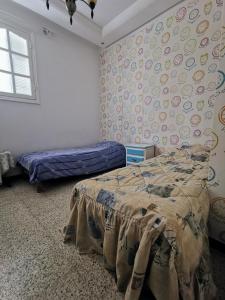 纳布勒Appartement standing Nabeul的一间卧室配有一张床,墙上挂着贴纸