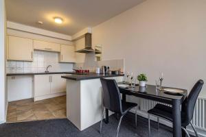 伊斯特伍德Modern flat in Eastwood Town centre的厨房以及带桌椅的用餐室。
