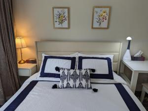 温哥华Nice home away at Vancouver near YVR的一间卧室配有一张带蓝色和白色枕头的床