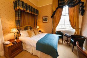 爱丁堡吉尔多南住宿酒店的配有一张床、一张书桌和一扇窗户的酒店客房