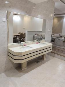 哈伊勒شاليه البستان حي المنتزه الغربي的一间带大镜子和盥洗盆的浴室