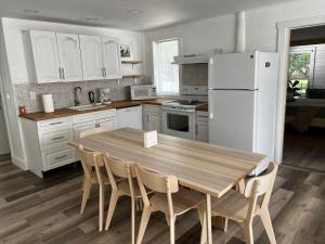 霍姆斯泰德Maria's Farm House的厨房配有木桌和白色冰箱。