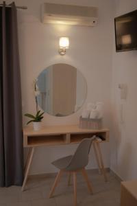 斯基亚索斯镇ATHANASIA APARTMENTS的浴室设有梳妆台、镜子和椅子
