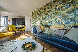 滕比Priory Bay Escapes - Matahari的客厅配有蓝色沙发和绘画作品