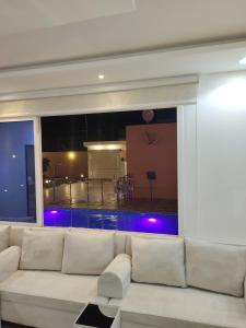 哈伊勒شاليه البستان حي المنتزه الغربي的一间带白色沙发的客厅和一个游泳池