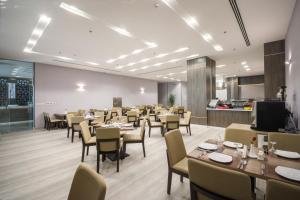 阿可贺巴Enala Hotel - Al Khobar的一间带桌椅的餐厅和一间厨房