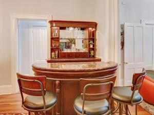 萨凡纳The Lyons House - Luxe Historical Home - Parking Included的一间酒吧,房间内设有三把椅子和一张桌子