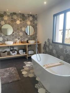 VeauchetteMaison au bord de Loire的带浴缸和两面镜子的浴室