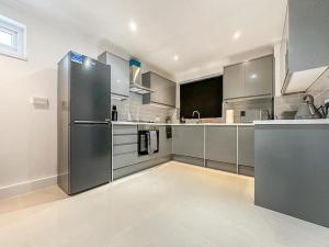 伦敦New Cosy Luxury 3 Bedroom House in Battersea London的厨房配有不锈钢冰箱