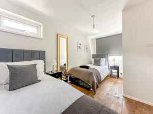 伦敦New Cosy Luxury 3 Bedroom House in Battersea London的一间卧室配有两张床和镜子
