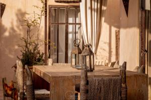 GhazouaDar Alya Essaouira Maison et table d'hôtes的一张木桌,上面有两盏灯笼