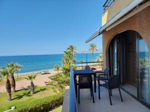 萨各夫雷纳FantaSea House Salobreña的阳台配有桌椅,享有海滩美景。