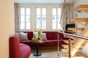 不莱梅施诺尔罗曼提度假屋的客厅设有红色沙发,配有窗户