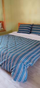 韦尔切利INTERNO 12的一张带蓝色和白色条纹棉被的床