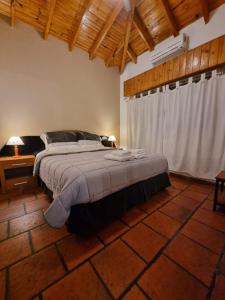 Tristán SuárezNagual -Ecolodge- Airport Shuttle & Restaurant的一间卧室设有一张大床和木制天花板