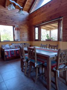 卡皮亚德尔德尔蒙特CABAÑAS ALMA SERENA的一间带木桌和椅子的用餐室