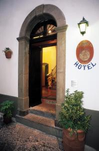 阿马尔菲Hotel Antica Repubblica in Amalfi center at 100mt from the sea with payment parking的拥有拱门和植物的酒店入口
