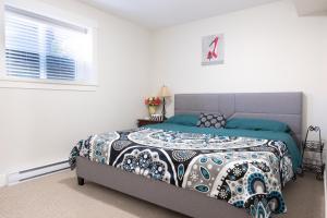 萨里Modern yet comfy 3 bed suite in Surrey的一间卧室配有一张带被子的床和一扇窗户