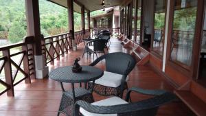巴色Phubachiang Golf and Resort Pakse的大楼内带桌椅的阳台