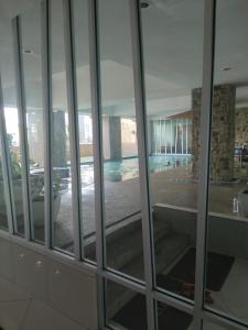 瓦卡夫车叶AL Fateh Apartment Wakaf Che Yeh的透过玻璃窗可欣赏到游泳池的景色