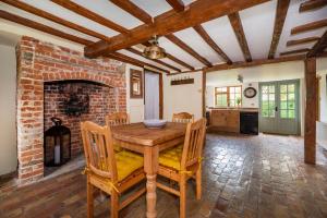 HartestButtercup Cottage, Hartest的一间带桌子和砖砌壁炉的用餐室