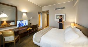 雅典德科里亚酒店的一位妇女站在酒店带床的房间