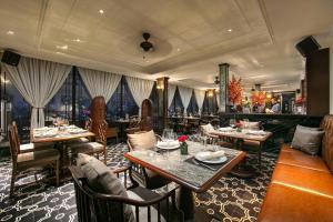河内La Mejor Hotel & Sky Bar的一间在房间内配有桌椅的餐厅