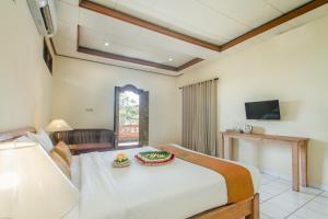 乌布KUDESA Homestay by Pramana Villas的卧室配有一张白色大床和电视。