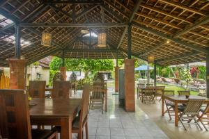 乌布KUDESA Homestay by Pramana Villas的一间带桌椅和遮阳伞的餐厅