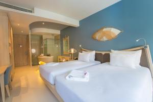 芭东海滩Beyond Patong的两张位于酒店客房的床,拥有蓝色的墙壁