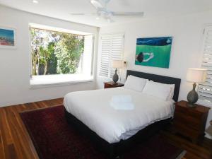 悉尼Clovelly Beach House with Pool的卧室配有白色的床和窗户。