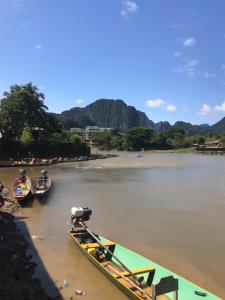 万荣Downtown Vang Vieng Hotel的一群船停靠在河上