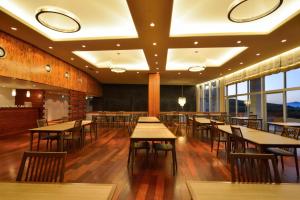 南小国町Senomoto Kogen Hotel的餐厅设有木桌、椅子和窗户。