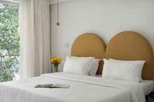 新德里Bungalow 157的一间卧室配有一张带白色床单的床和一扇窗户。