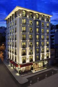 伊斯坦布尔伊斯坦布尔图标酒店的一座白色的大建筑,晚上有很多窗户
