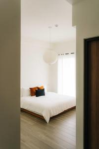 宜兰市無處 Nowhere Retreat 獨棟空間的卧室配有白色的床和大窗户