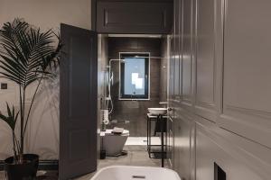 拉巴特Rabat l.o. MDINA-Designer House THE BEDROOM-TUB的一间带卫生间、水槽和镜子的浴室