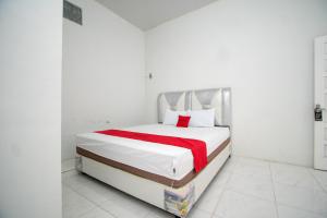 TakengonRedDoorz Syariah near Danau Lut Tawar Takengon 2的白色卧室配有一张带红色毯子的床