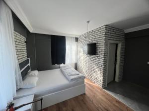 图兹拉Karaca Suite的卧室配有白色的床和砖墙