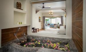 暹粒Sala Siem Reap Hotel的浴室内装有鲜花的水槽